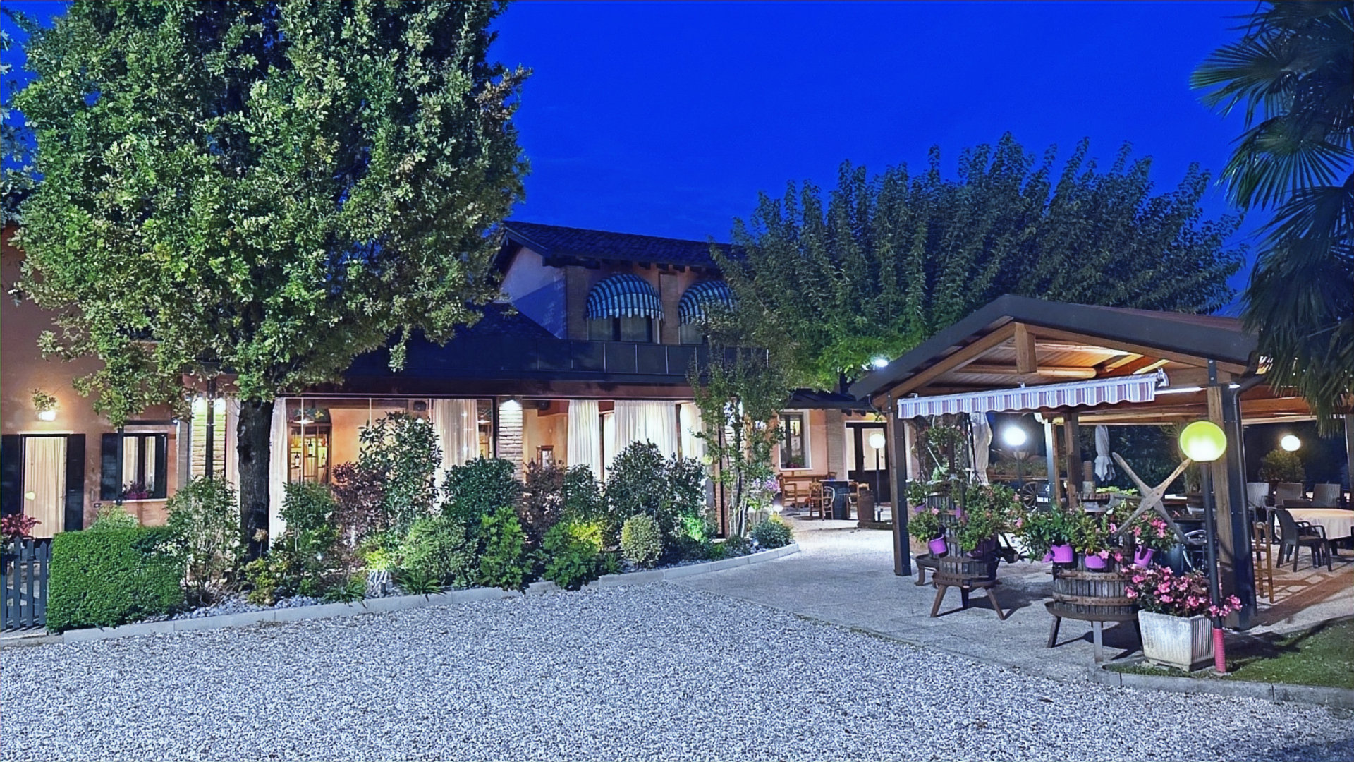 Esterno Osteria Pajer di sera – giardino illuminato